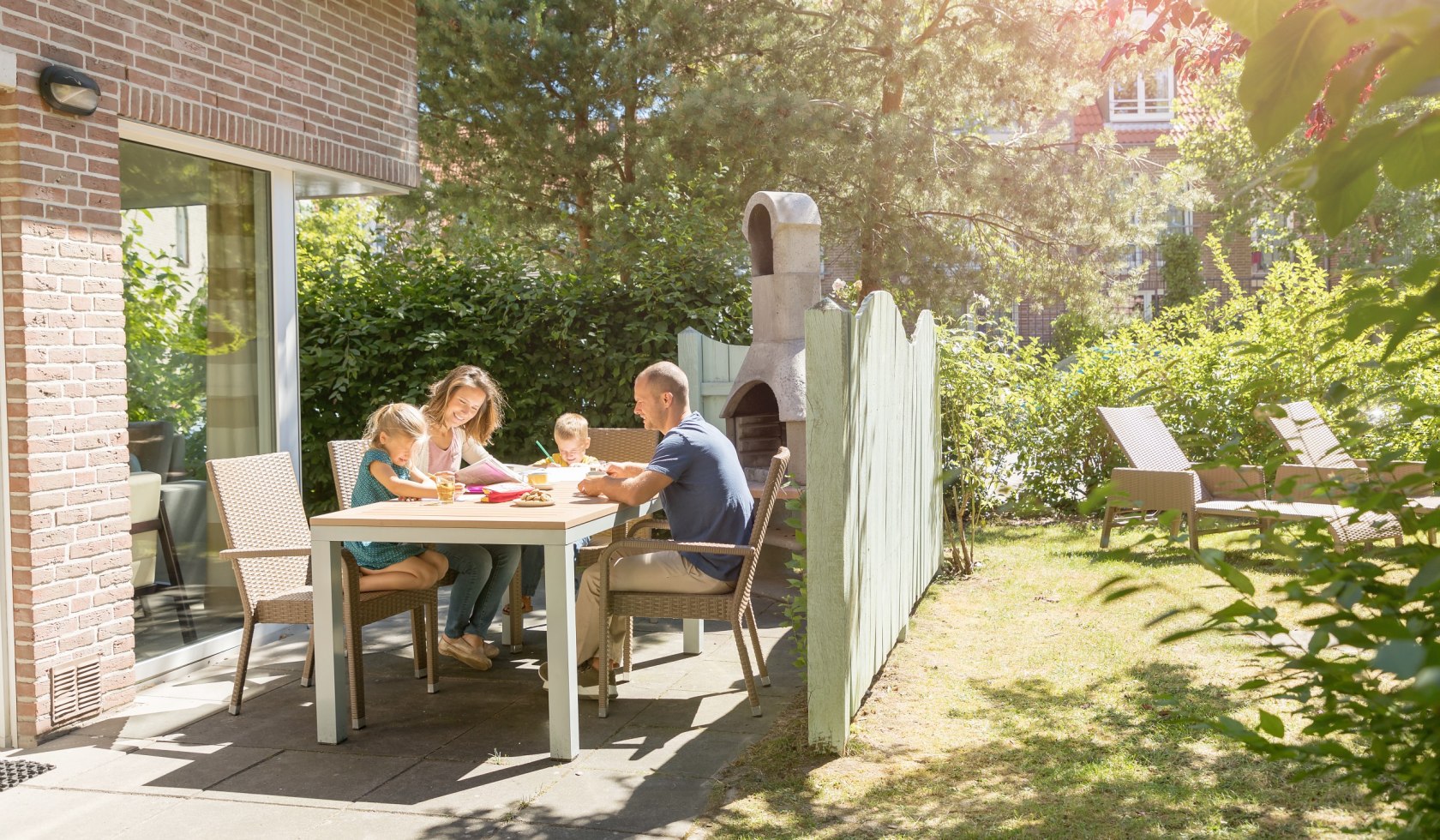 Family sitting on the terrace in front of the holiday home., © Center Parcs