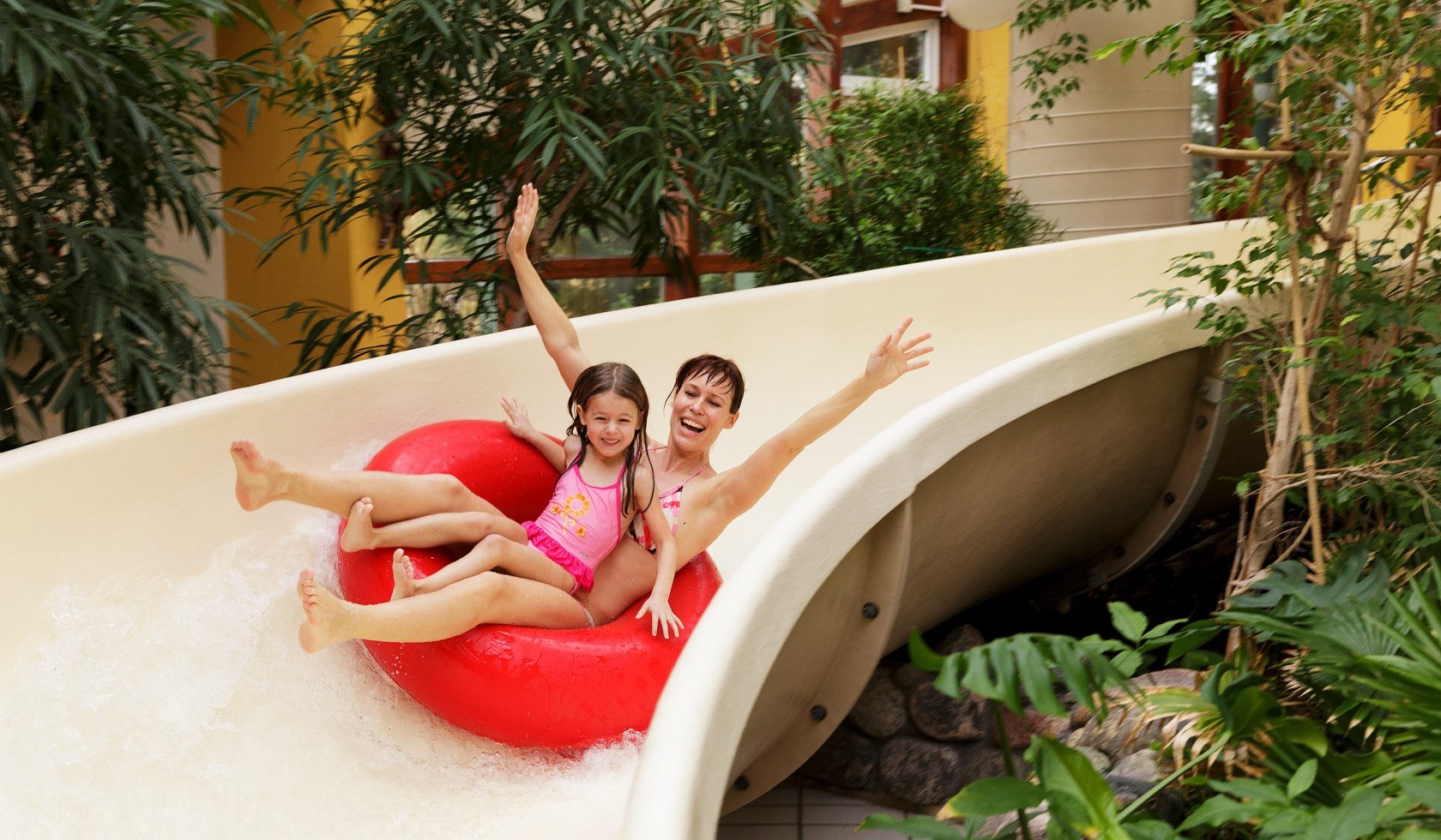 Mother and daughter on the tyre slide in the swimming pool., © Center Parcs